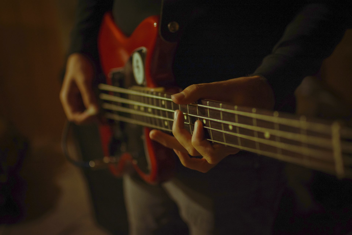 person playing red electric guitar